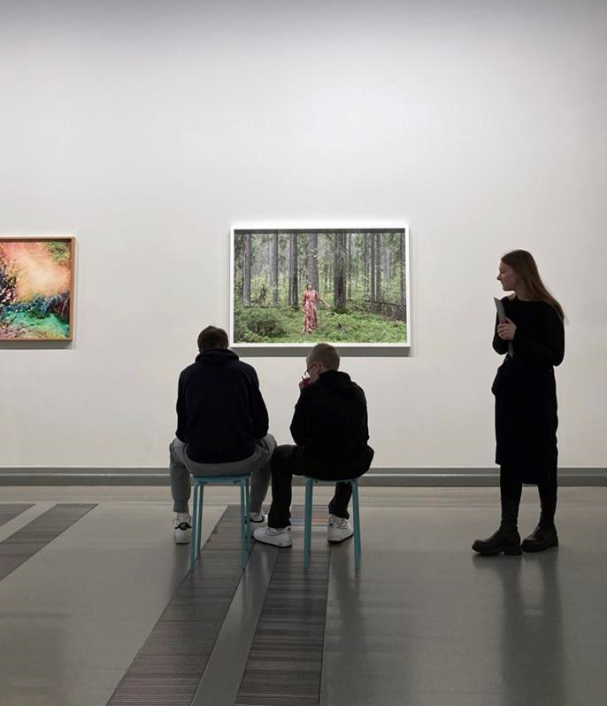 Taidetestaajia syventymässä teoksiin ja tehtäviin Handle with Care -näyttelyssä.