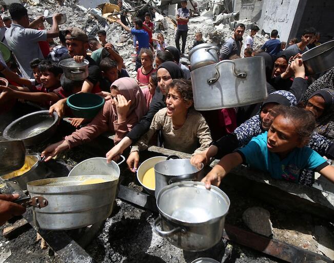 Ihmiset jonottivat kattiloidensa kanssa saadakseen ruokaa Jabaliassa Pohjois-Gazassa 19. toukokuuta.