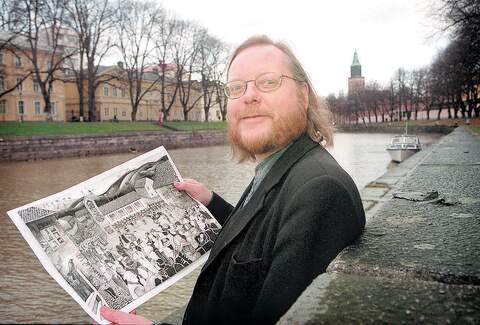 Simo Tuomola esittelemässä ensimmäisen Turun historiaa käsittelevän kirjansa tapahtumapaikkoja Aurajoen rannalla marraskuussa 1999.