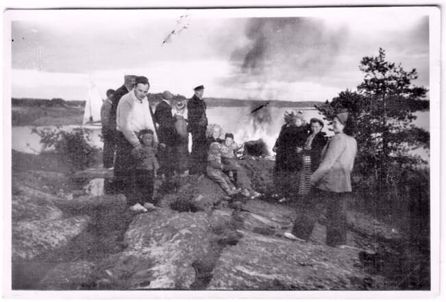 Pitkäkari oli muutakin kuin pelkkä veneiden tukikohta. Saarella vietettiin kesäisin vapaa-aikaa perheiden kesken. Kuvassa pursiseuralaiset ovat kokoontuneet juhannuskokon ääreen vuonna 1949. 