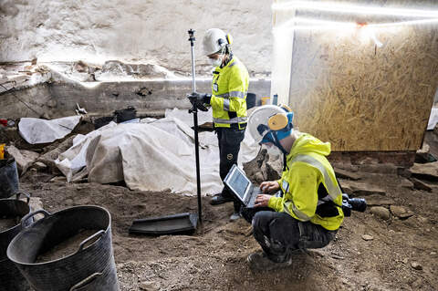 Arkeologit Lauretta Suomi (vas.), ja Marja Ronkainen dokumentoivat kirkon lattian alta löytynyttä hautaa viime kesänä. Kaivaukset aiheuttivat kuukausien katkon peruskorjaukseen.
