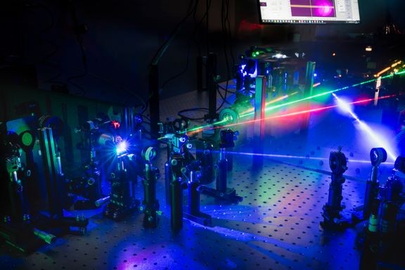 Laserlaboratorio, jossa tutkimus toteutettiin. Lasersäteellä viritetään liuosprosessoinnilla valmistettuja orgaanisia mikrokaviteetteja, mikä johtaa polaritonilaseriin ja mahdollistaa valon ja aineen välisen vahvan vuorovaikutuksen näkyvät vaikutukset.
