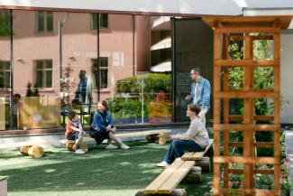 Perhe viettämässä syyslomaa pääkirjaston Kirjastopihalla.
