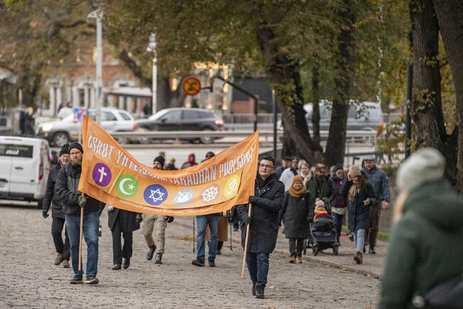 Jukka Seppälä (vas.) ja Murat Sarigül kantoivat banderollia eri uskontokuntien yhteisellä rauhankävelyllä Turun keskustassa vuonna 2023.